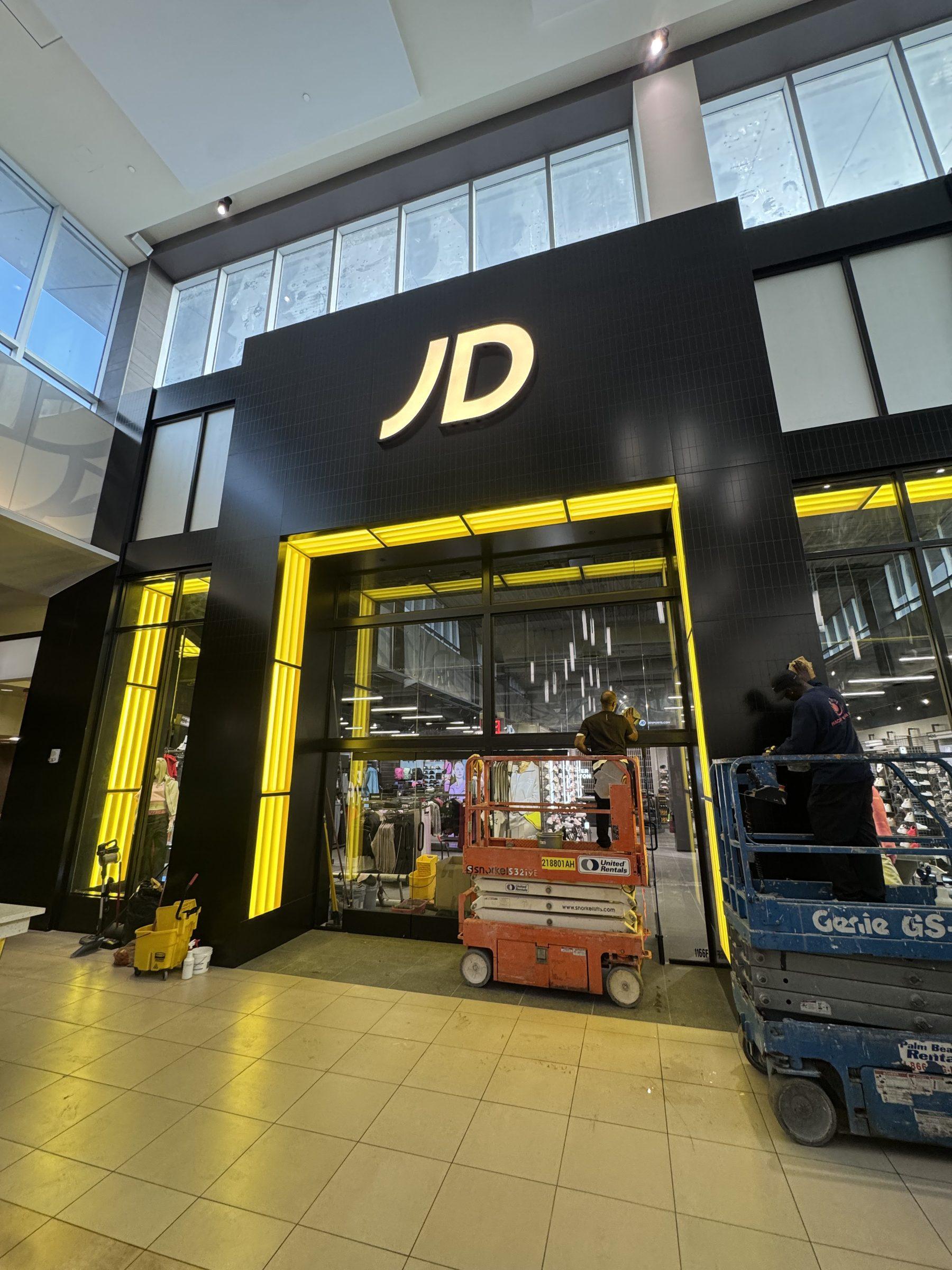 Peachy Klean crew on scissor lifts detailing a JD Sports storefront during a mall build-out