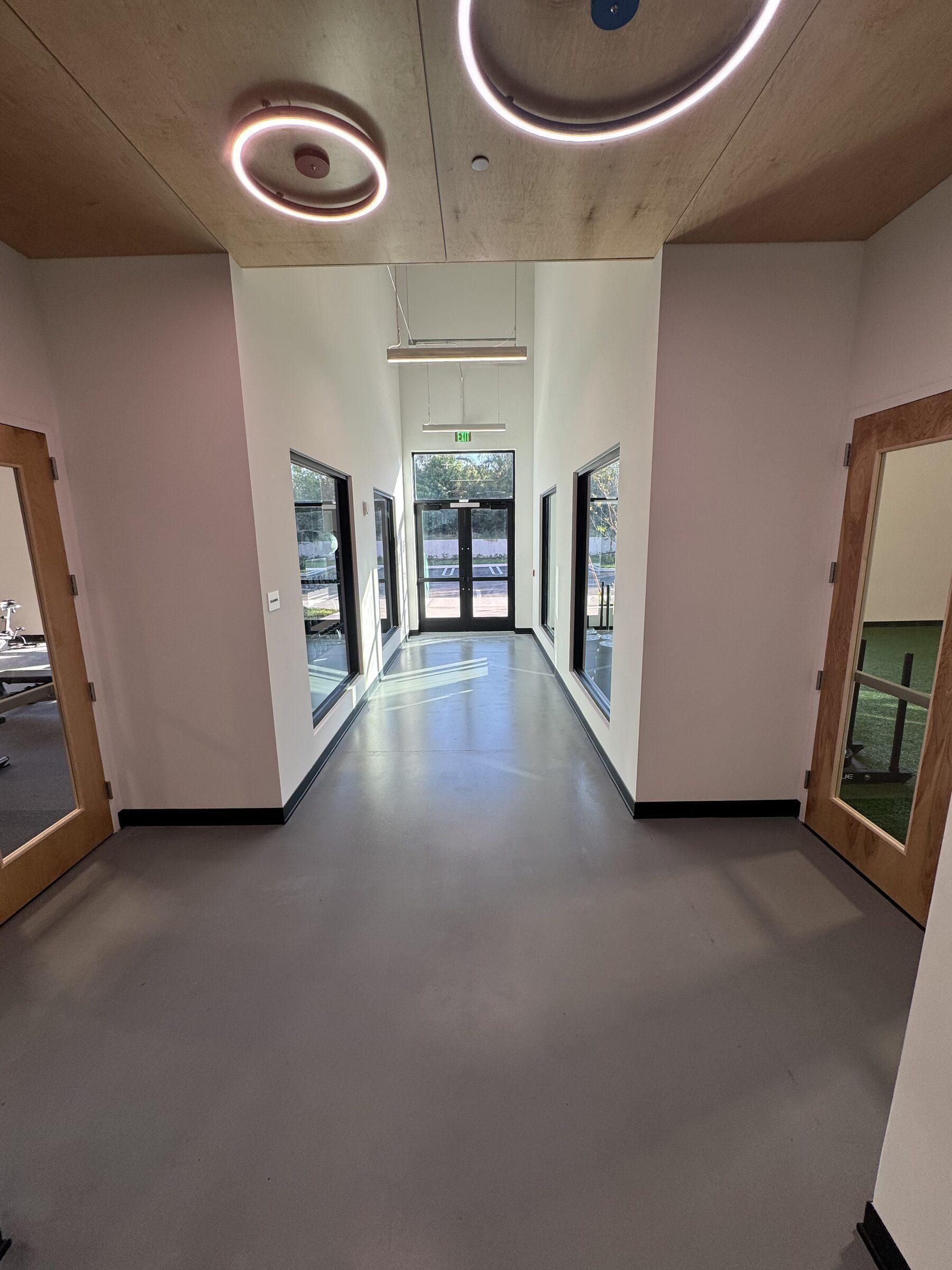 Polished concrete hallway with ring lights after a night clean